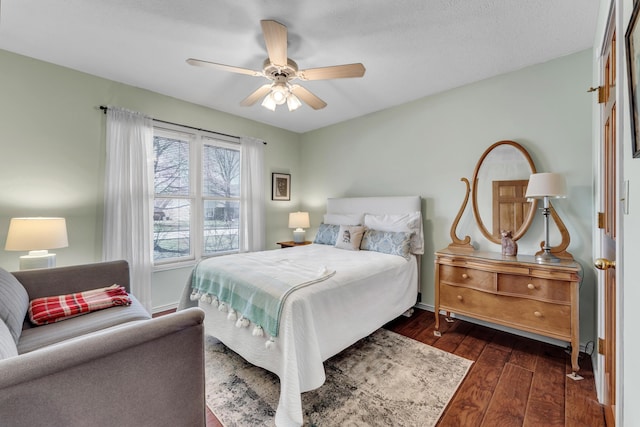 bedroom featuring a ceiling fan, dark wood-style flooring, and baseboards