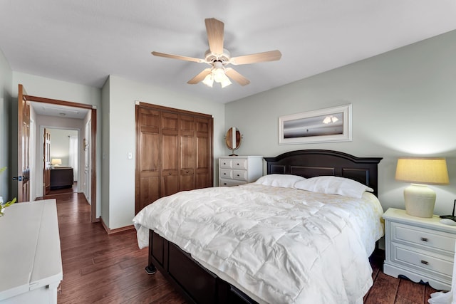 bedroom featuring a ceiling fan, a closet, dark wood-style flooring, and baseboards