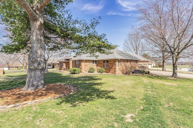 view of front of house featuring driveway, a front lawn, a shingled roof, a garage, and brick siding