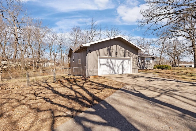 exterior space with fence, a garage, and driveway