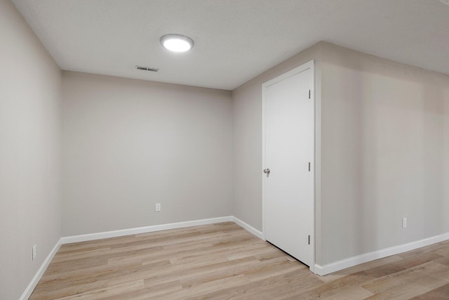 empty room with visible vents, baseboards, and light wood-style floors