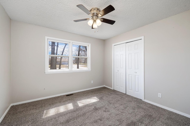 unfurnished bedroom featuring carpet, visible vents, baseboards, a closet, and a textured ceiling