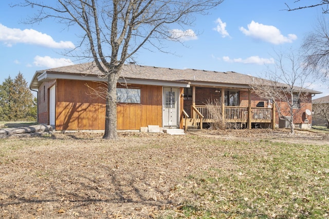 single story home with a deck, an attached garage, and brick siding