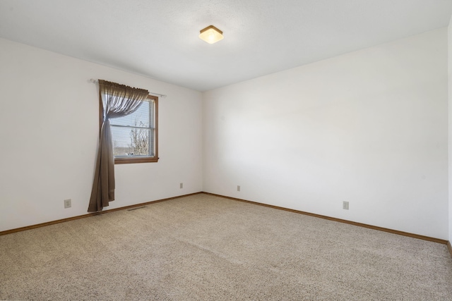 unfurnished room with visible vents, baseboards, and light colored carpet