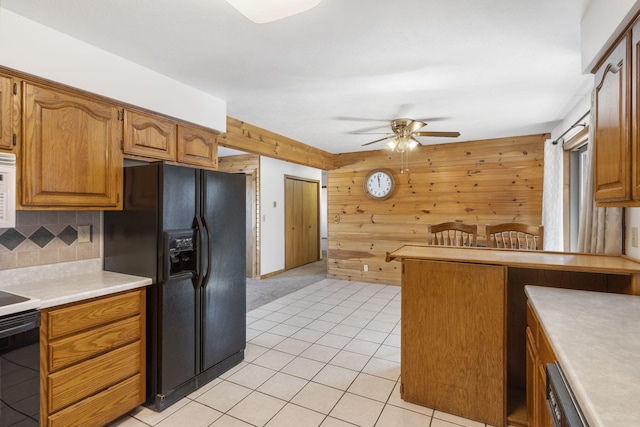 kitchen featuring white microwave, backsplash, ceiling fan, light countertops, and black refrigerator with ice dispenser