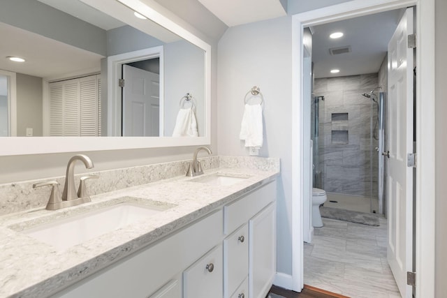 full bath with a stall shower, toilet, visible vents, and a sink