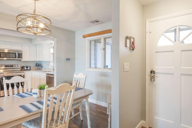 dining area featuring a wealth of natural light, visible vents, baseboards, and a notable chandelier