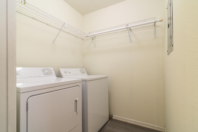 laundry area with laundry area, separate washer and dryer, dark wood-style flooring, and baseboards