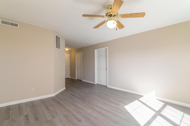 empty room with visible vents, baseboards, ceiling fan, and wood finished floors