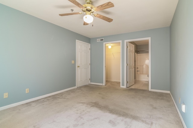 unfurnished bedroom with visible vents, a walk in closet, baseboards, carpet, and a closet