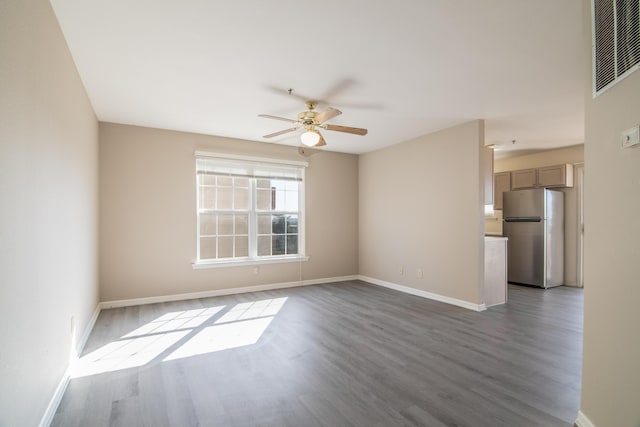 unfurnished room featuring visible vents, baseboards, a ceiling fan, and wood finished floors