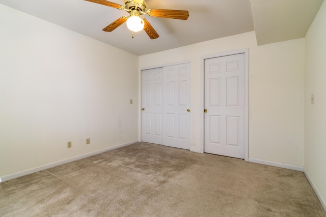 unfurnished bedroom featuring light colored carpet, a ceiling fan, and baseboards