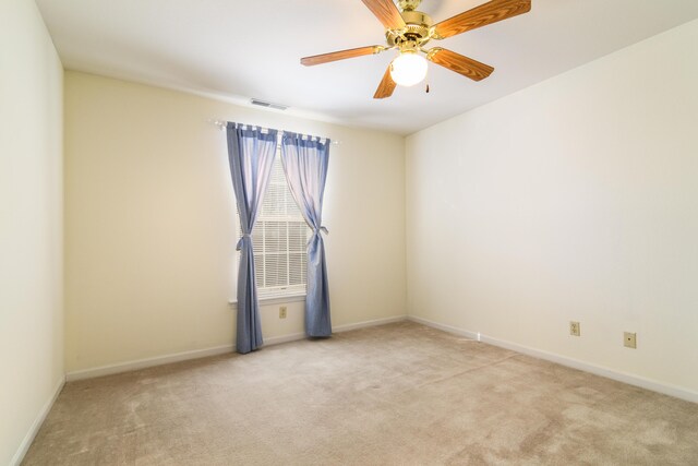 carpeted spare room featuring a ceiling fan, baseboards, and visible vents