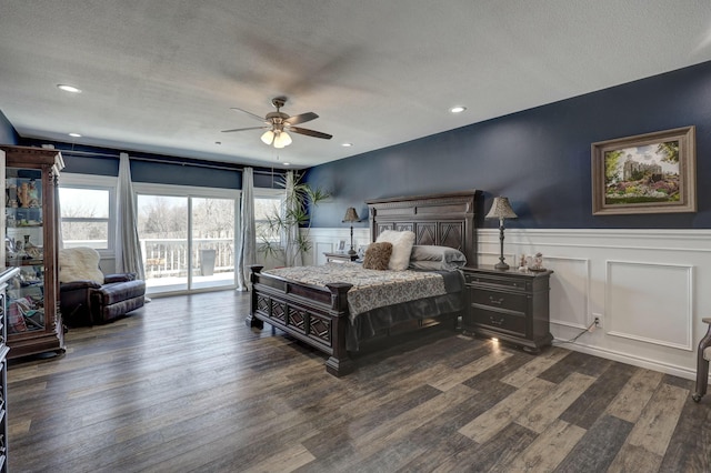 bedroom with dark wood finished floors, access to exterior, a ceiling fan, and a wainscoted wall