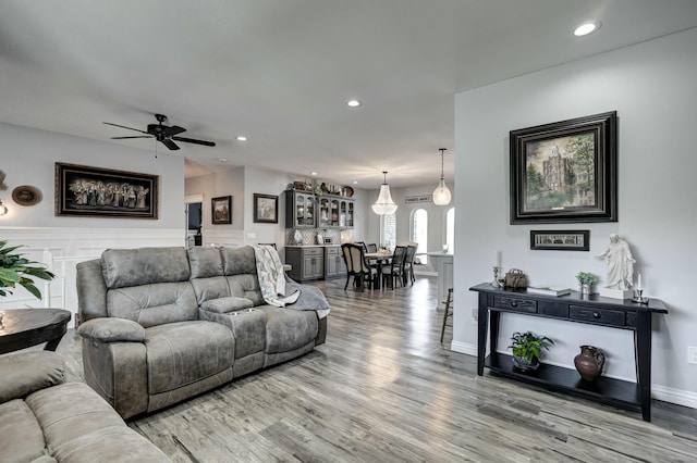 living area with wainscoting, recessed lighting, ceiling fan, and wood finished floors