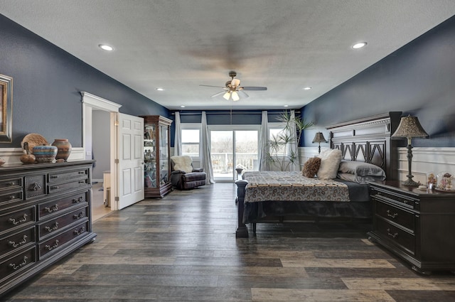 bedroom with wood finished floors, a wainscoted wall, and a textured ceiling