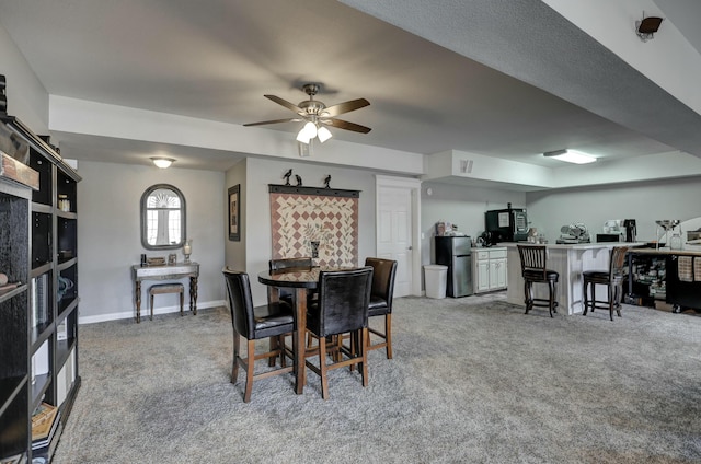 dining space with visible vents, baseboards, a ceiling fan, and carpet flooring