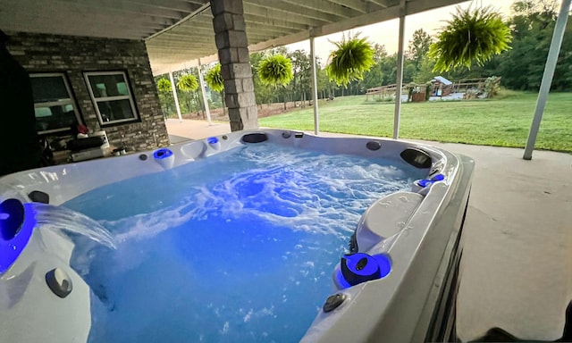 view of swimming pool featuring a hot tub and a yard