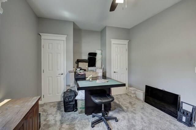 carpeted home office featuring ceiling fan