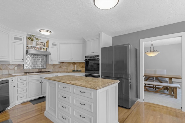 kitchen featuring light wood-type flooring, tasteful backsplash, appliances with stainless steel finishes, and white cabinetry