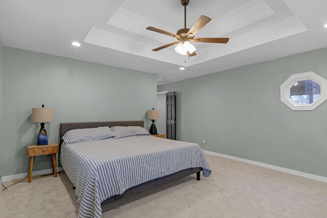 bedroom with carpet, baseboards, recessed lighting, a raised ceiling, and a ceiling fan