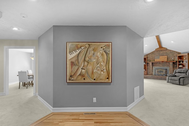 corridor with carpet flooring, baseboards, visible vents, and vaulted ceiling with beams