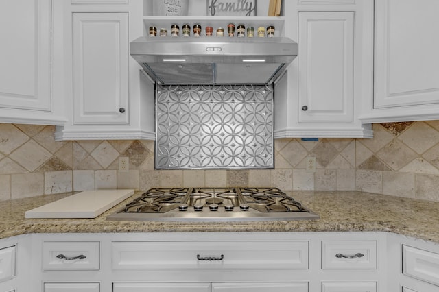 kitchen featuring light stone counters, decorative backsplash, stainless steel gas stovetop, white cabinetry, and open shelves