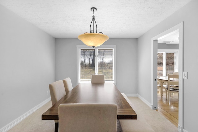 dining space featuring baseboards and a textured ceiling