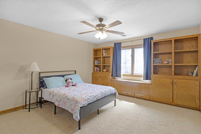 bedroom with baseboards, ceiling fan, a textured ceiling, and carpet