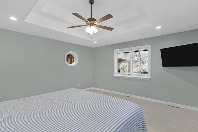 bedroom featuring recessed lighting, baseboards, a raised ceiling, and light colored carpet