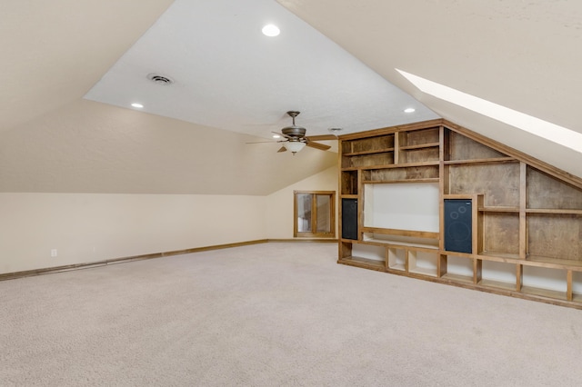 additional living space with visible vents, lofted ceiling with skylight, carpet, and ceiling fan