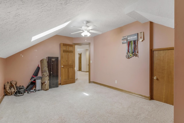 additional living space with carpet, a ceiling fan, and a textured ceiling