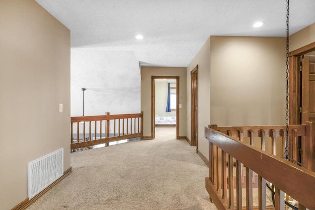 hallway with visible vents, an upstairs landing, recessed lighting, carpet floors, and baseboards