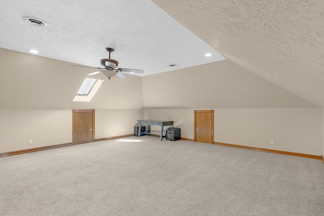 bonus room with a textured ceiling, visible vents, baseboards, and ceiling fan