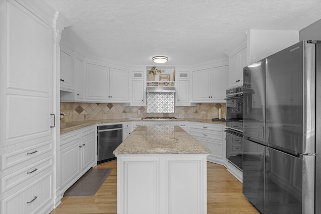 kitchen featuring white cabinets, light wood-style flooring, appliances with stainless steel finishes, and a center island