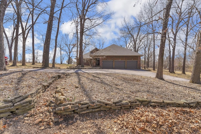 view of front of house with brick siding, driveway, and a garage