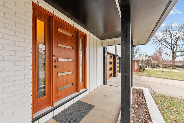 entrance to property with brick siding and a porch