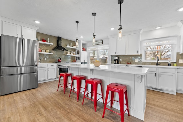 kitchen with visible vents, wall chimney range hood, light countertops, stainless steel appliances, and open shelves