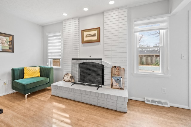 living area featuring visible vents, a healthy amount of sunlight, and baseboards