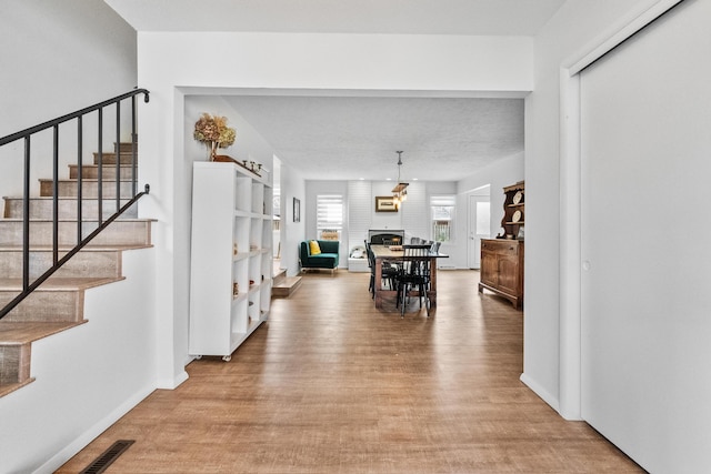 interior space featuring stairs, a fireplace, visible vents, and light wood-type flooring