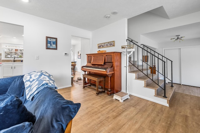 living room featuring stairs, baseboards, and wood finished floors