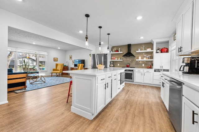 kitchen with light wood-type flooring, open shelves, stainless steel appliances, wall chimney exhaust hood, and light countertops