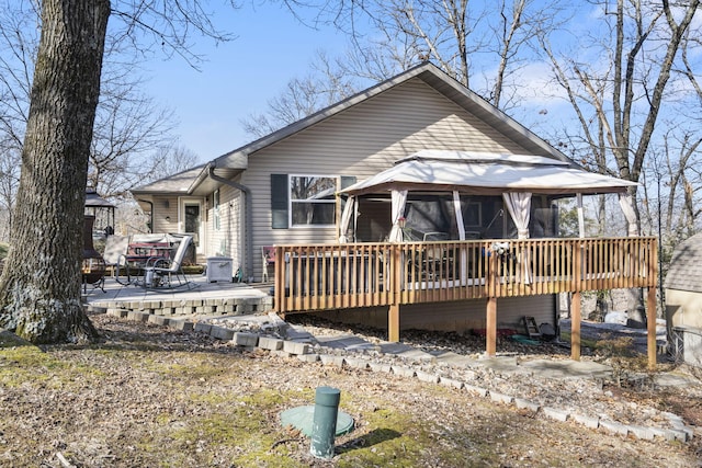 rear view of house with a gazebo and a wooden deck