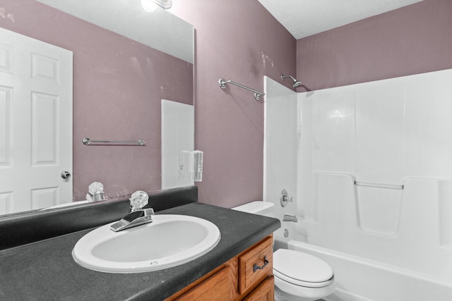 bathroom with vanity,  shower combination, toilet, and a textured ceiling