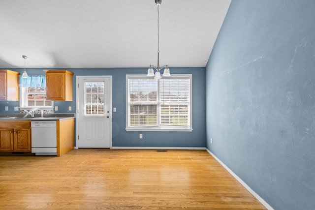 kitchen with dishwasher, a wealth of natural light, brown cabinetry, and light wood finished floors