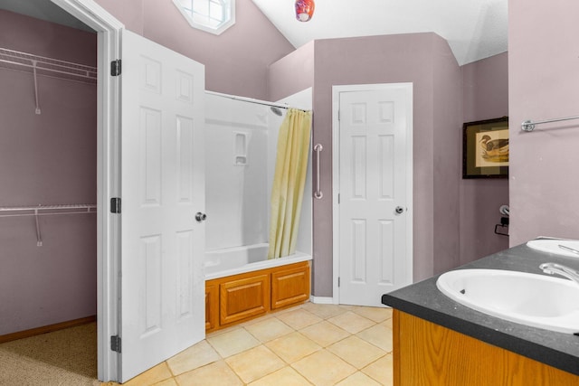 full bath with tile patterned flooring, a walk in closet, double vanity, shower / tub combo, and a sink