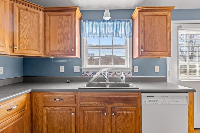 kitchen with dishwasher, pendant lighting, brown cabinets, and a sink