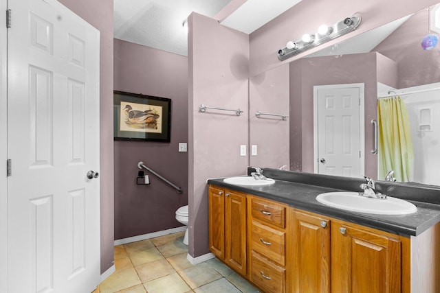 bathroom featuring a sink, toilet, double vanity, and tile patterned flooring