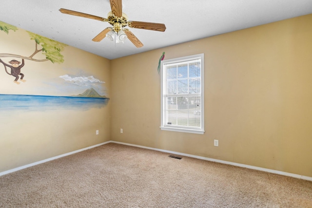 unfurnished room featuring baseboards, carpet, visible vents, and ceiling fan