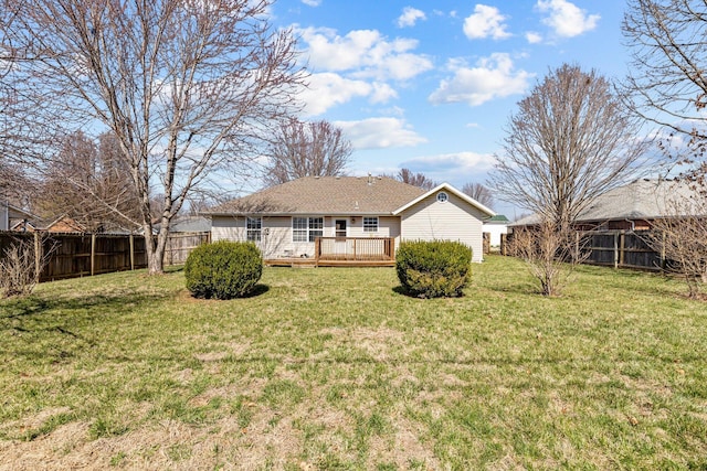 rear view of property with a deck, a lawn, and a fenced backyard